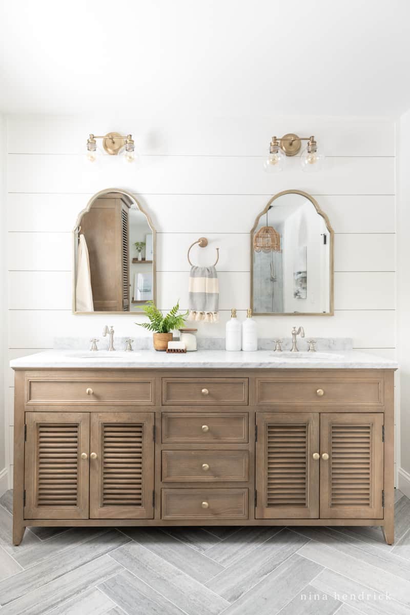 Wood vanity with louvered doors and marble countertop