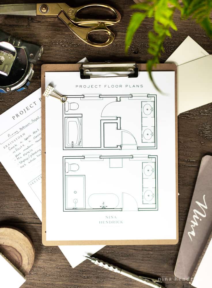 Primary bathroom floor plan layout changes displayed on a clipboard