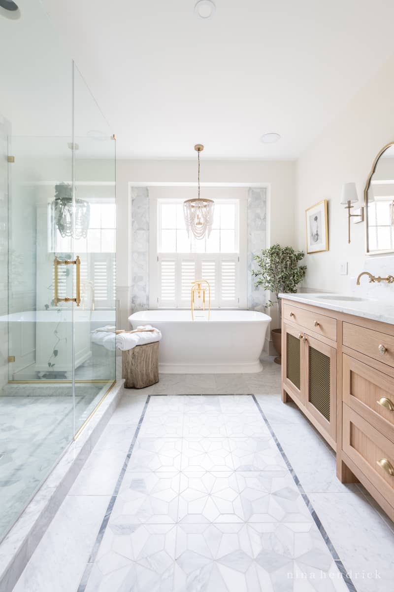 Inlaid bathroom floor tile design with marble shapes and a contrasting border