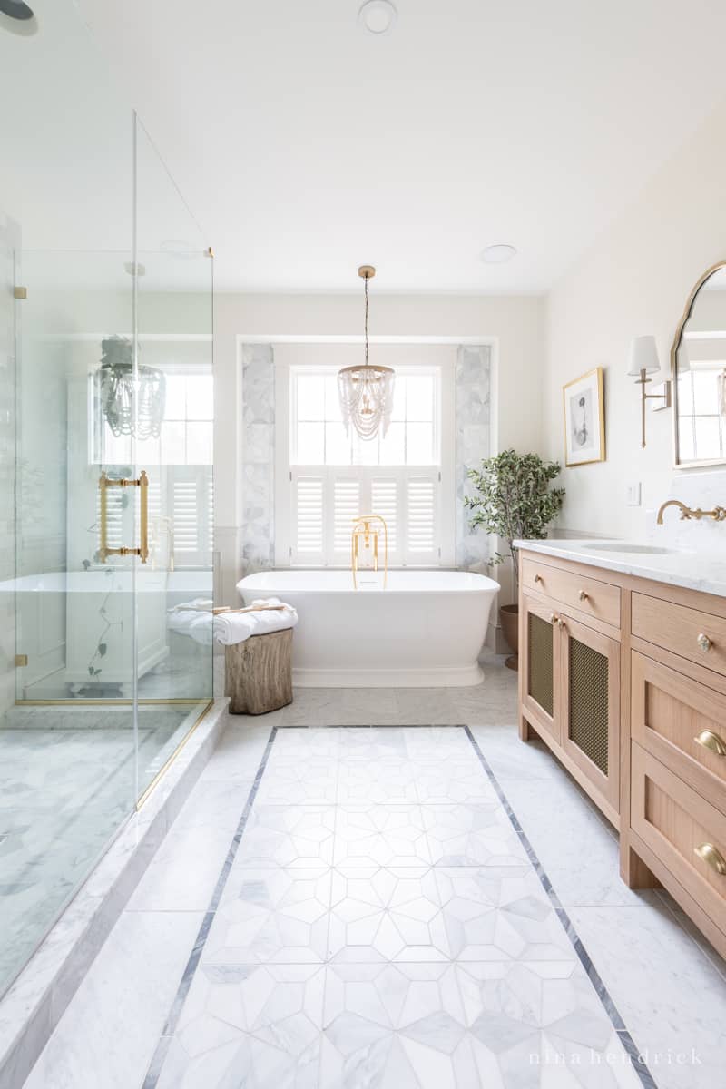 Inlaid bathroom floor tile design with marble shapes and a contrasting border  