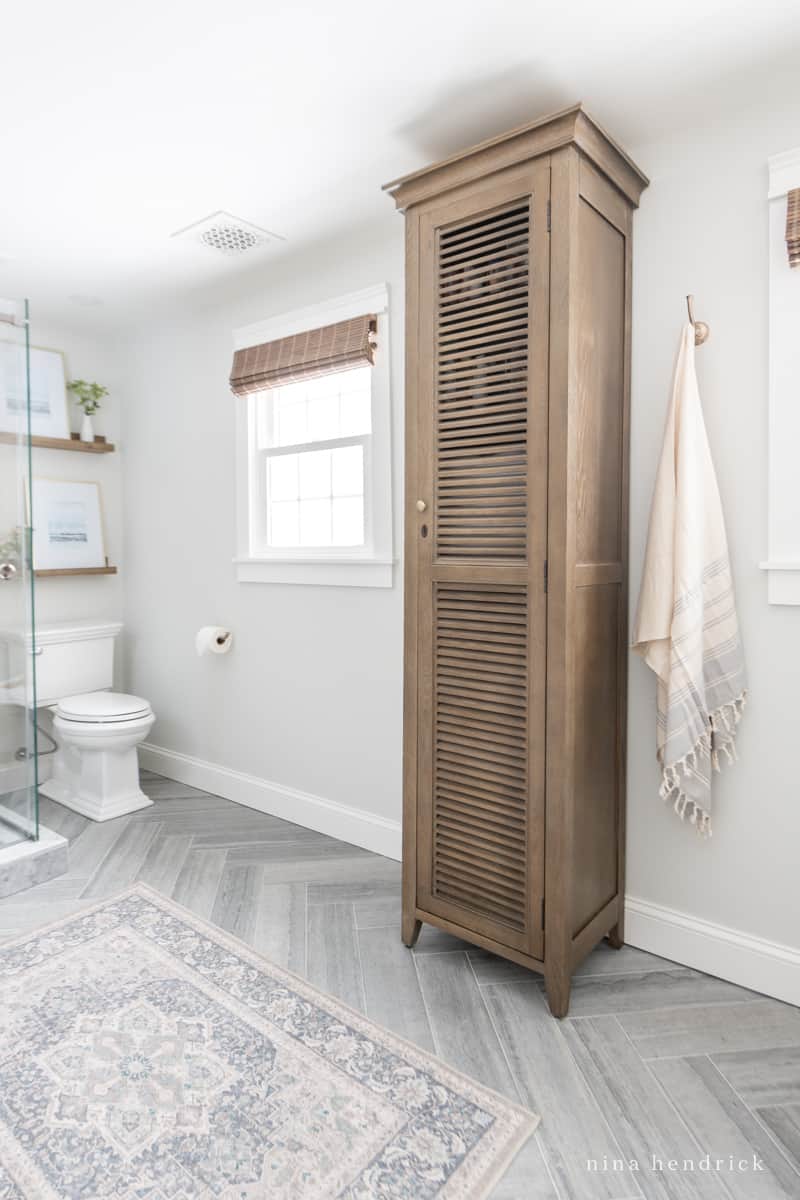 Wood bathroom storage tower with slatted door