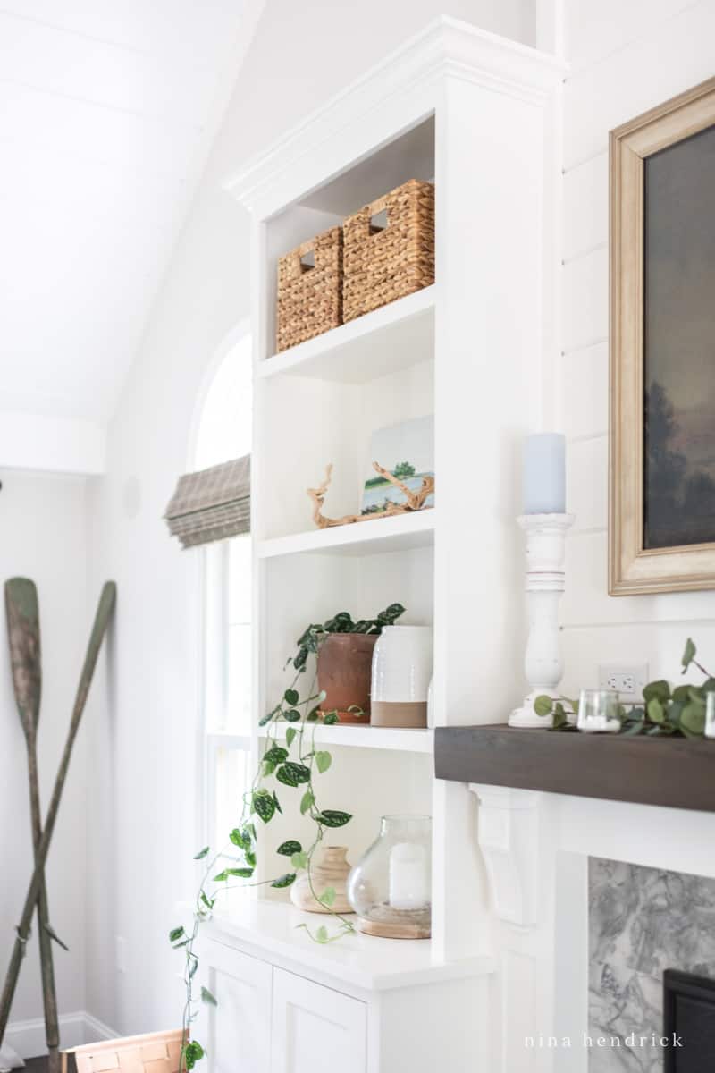 Coastal built-in bookshelf with decor ideas like vases and candlestick plus storage baskets on the top shelf