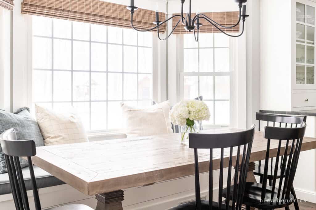 Breakfast Nook Refresh with black chairs and light fixture with woven shade and wood table