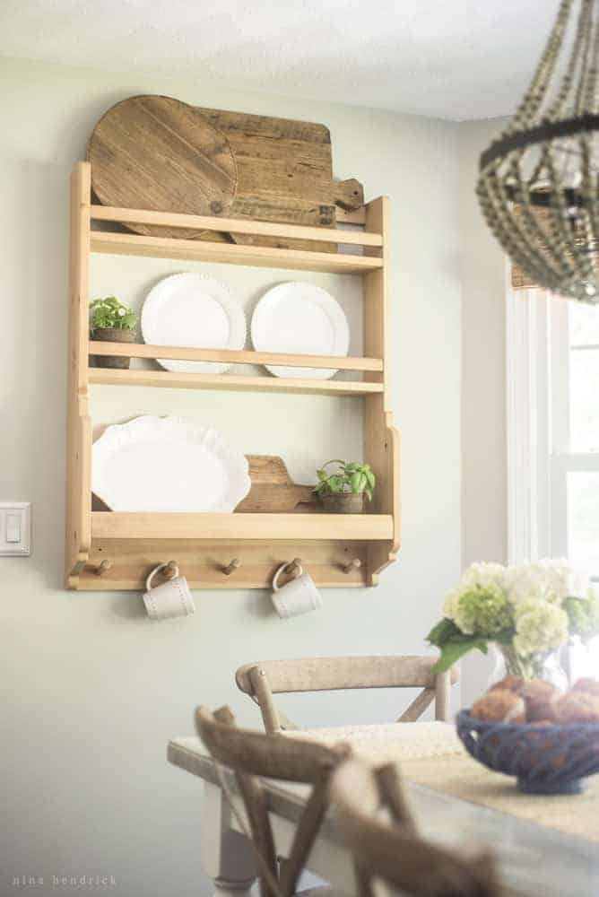 Image of ikea shelf with plates, cutting boards, small plants, and coffee mugs