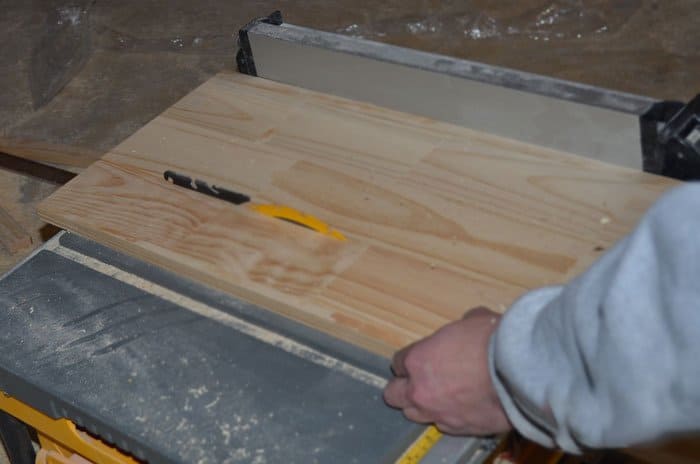 Cutting a shelf board width-wise with a table saw.