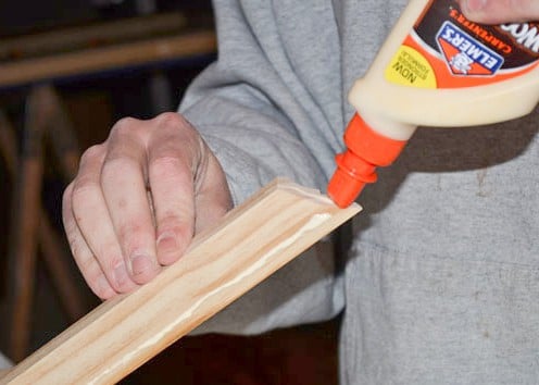Applying wood glue to crown moulding