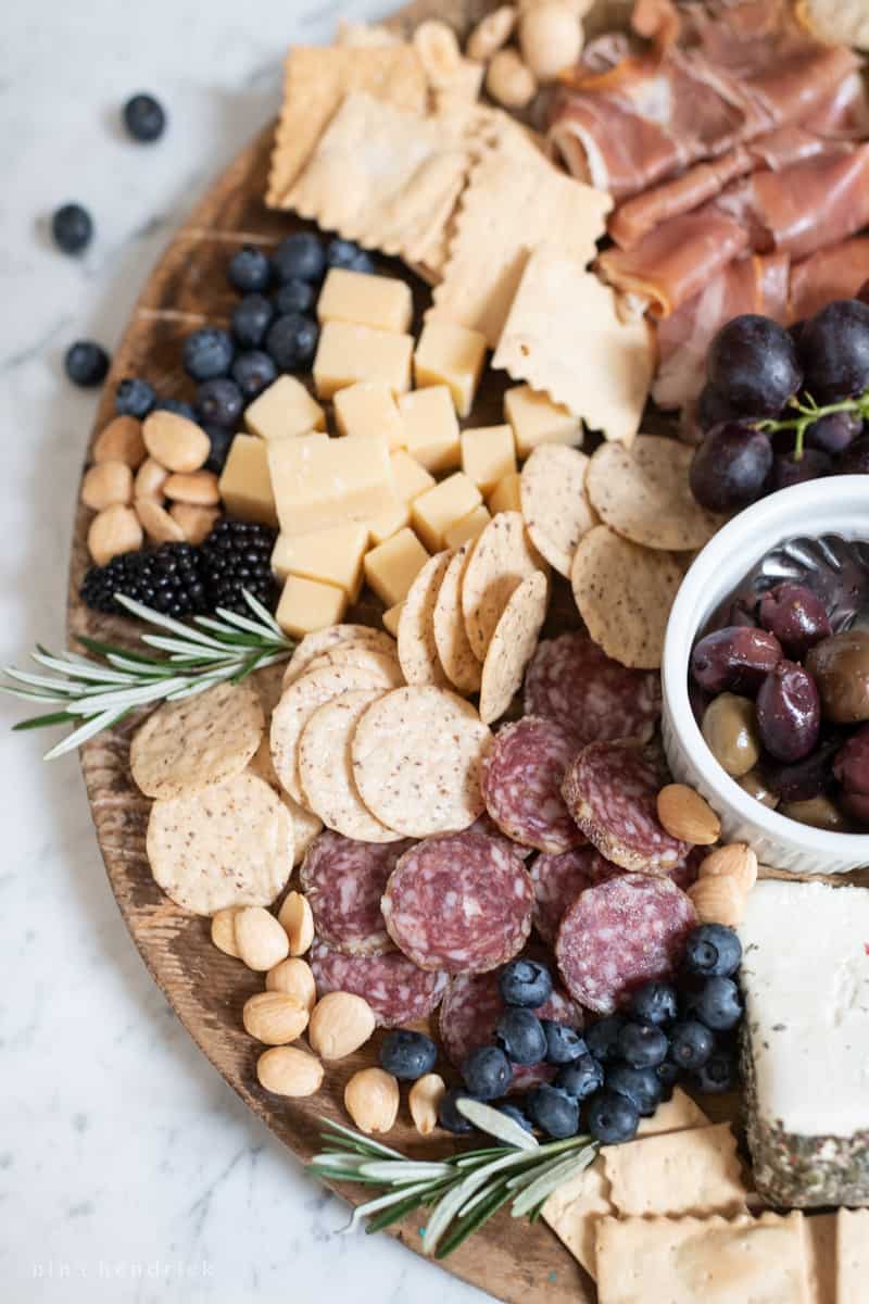 Portrait close up of part of a wooden board covered in appetizers