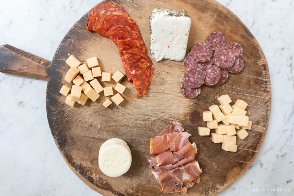 Creating a charcuterie board with cured meats and cheese