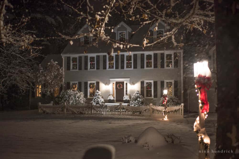 Christmas lights at night and a colonial decorated for the holidays