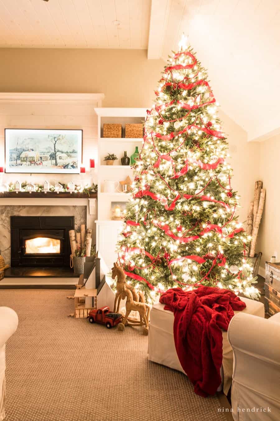 Cozy chair in front of Christmas lights in nighttime family room with fireplace