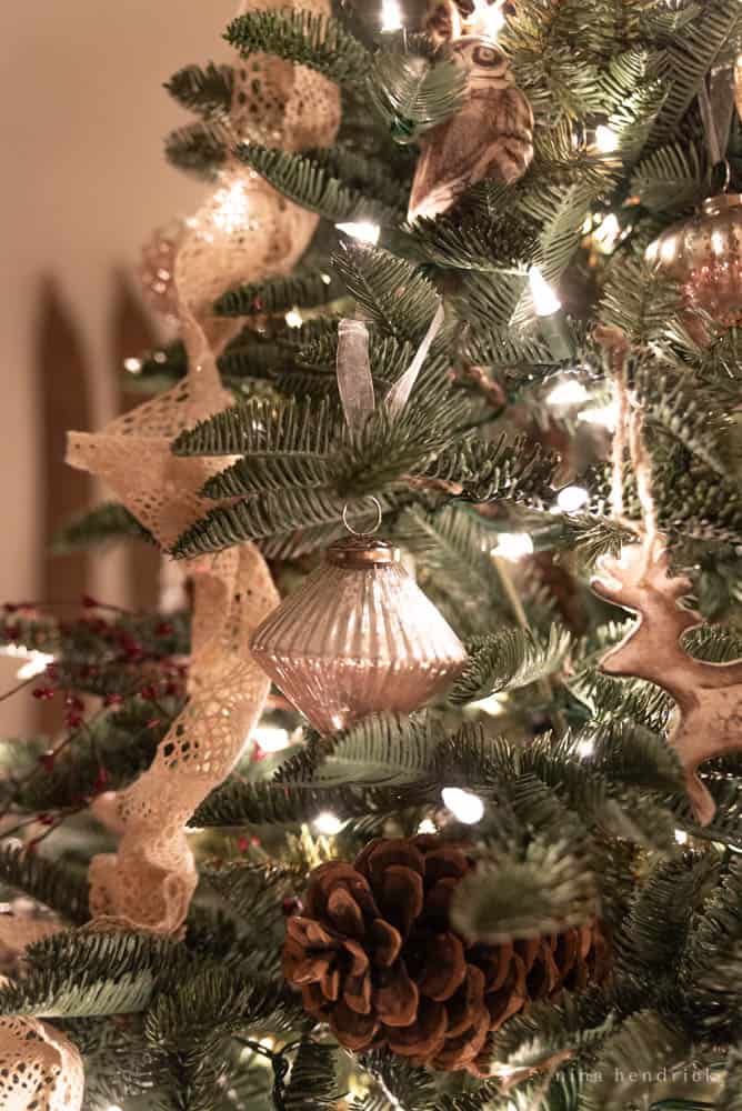 Mercury Glass ornaments and pinecones on a Christmas tree with lights