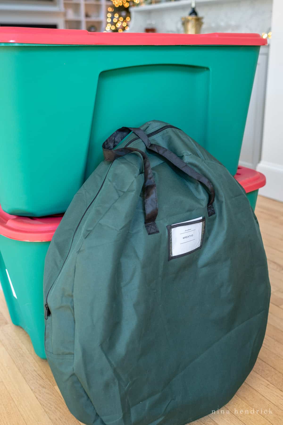 Christmas wreath storage bag with red and green bins in background