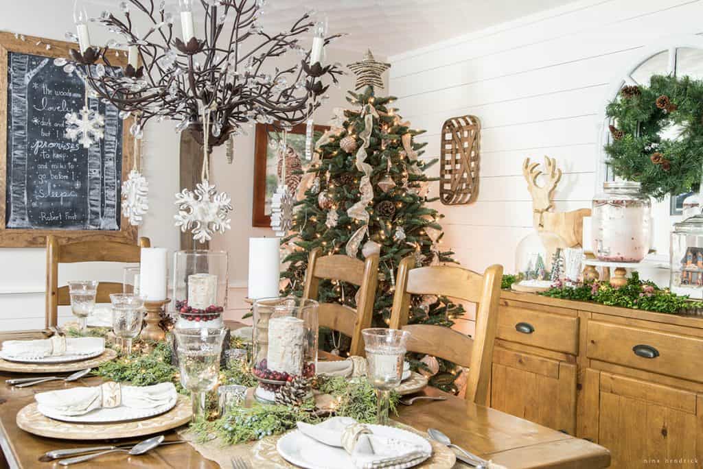 Christmas 2016 Nina Hendrick Holiday Housewalk | Gather inspiration from this tablescape with wood chargers, juniper greens, and hurricane luminaries.