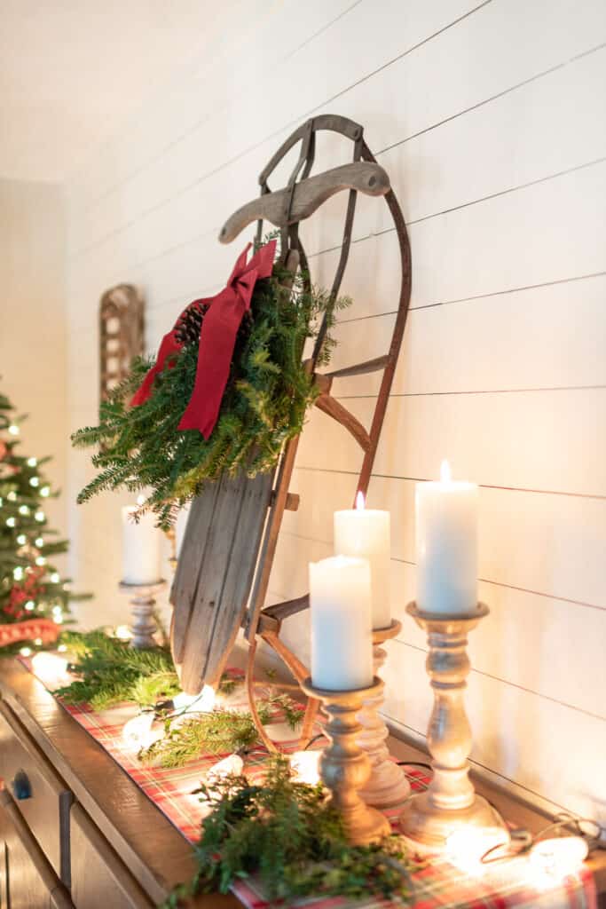 Vintage sled with an evergreen swag surrounded by white candles