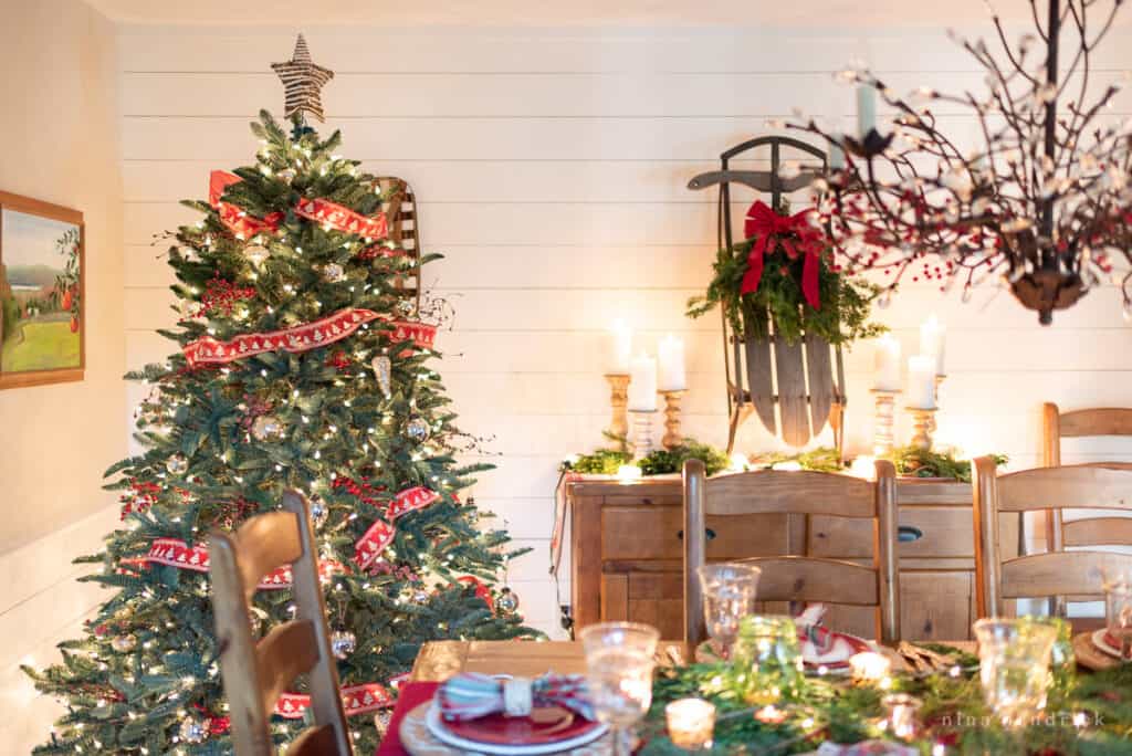 Christmas tree in the dining room decorated with red ribbon and berries