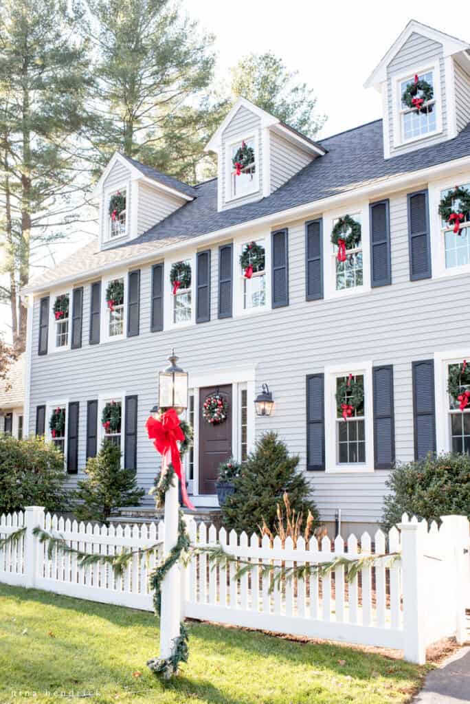 Exterior with Gray huskie paint and red bows adorning holiday wreaths in the windows