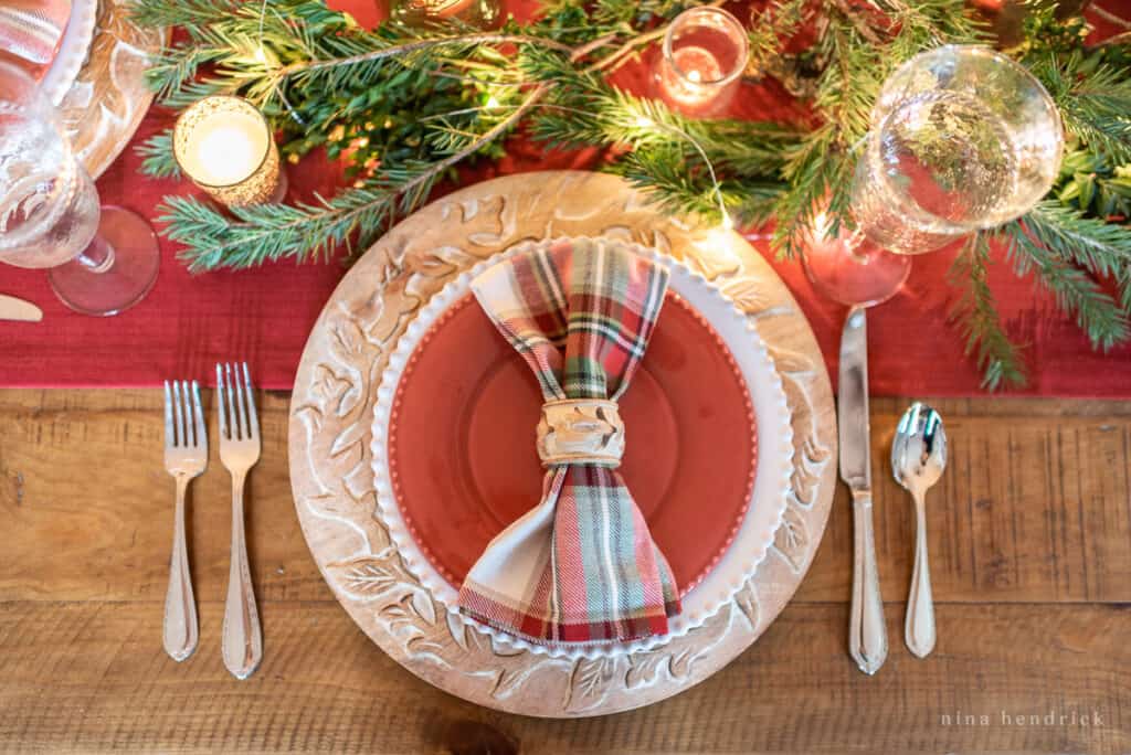 Gather inspiration for your holiday entertaining with this Classic Christmas Tablescape featuring traditional reds and greens. Christmas place setting with red and green plaid napkins