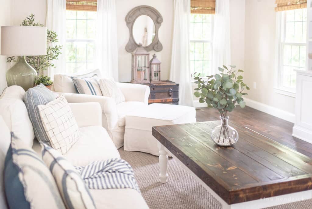 Living room with light couches and a dark wood coffee table. 