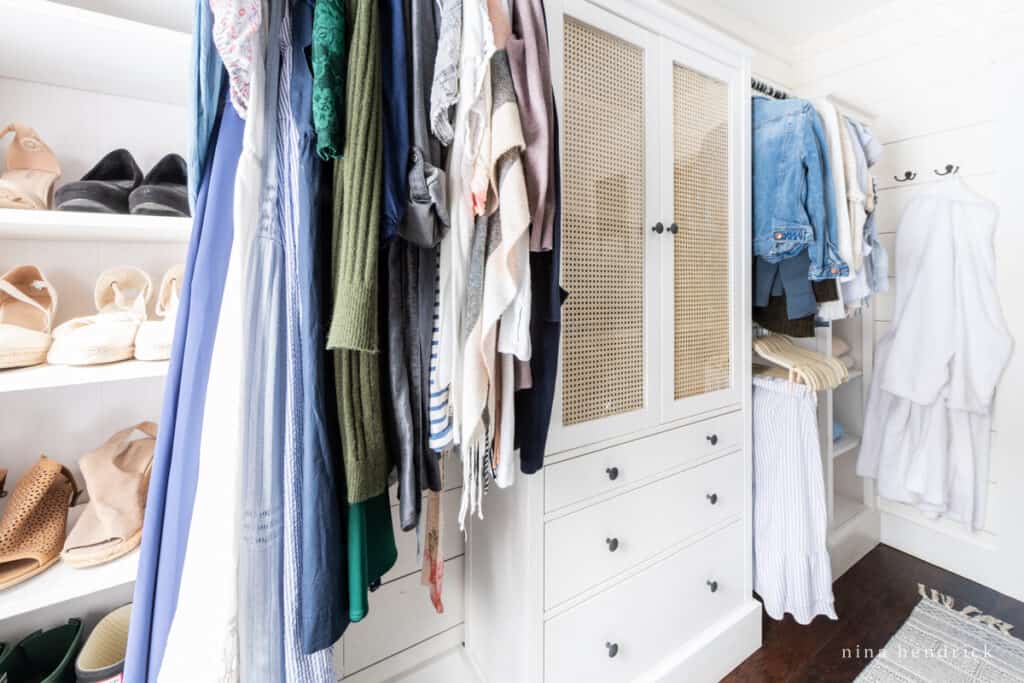 Organized closet with clothes hanging between cabinets