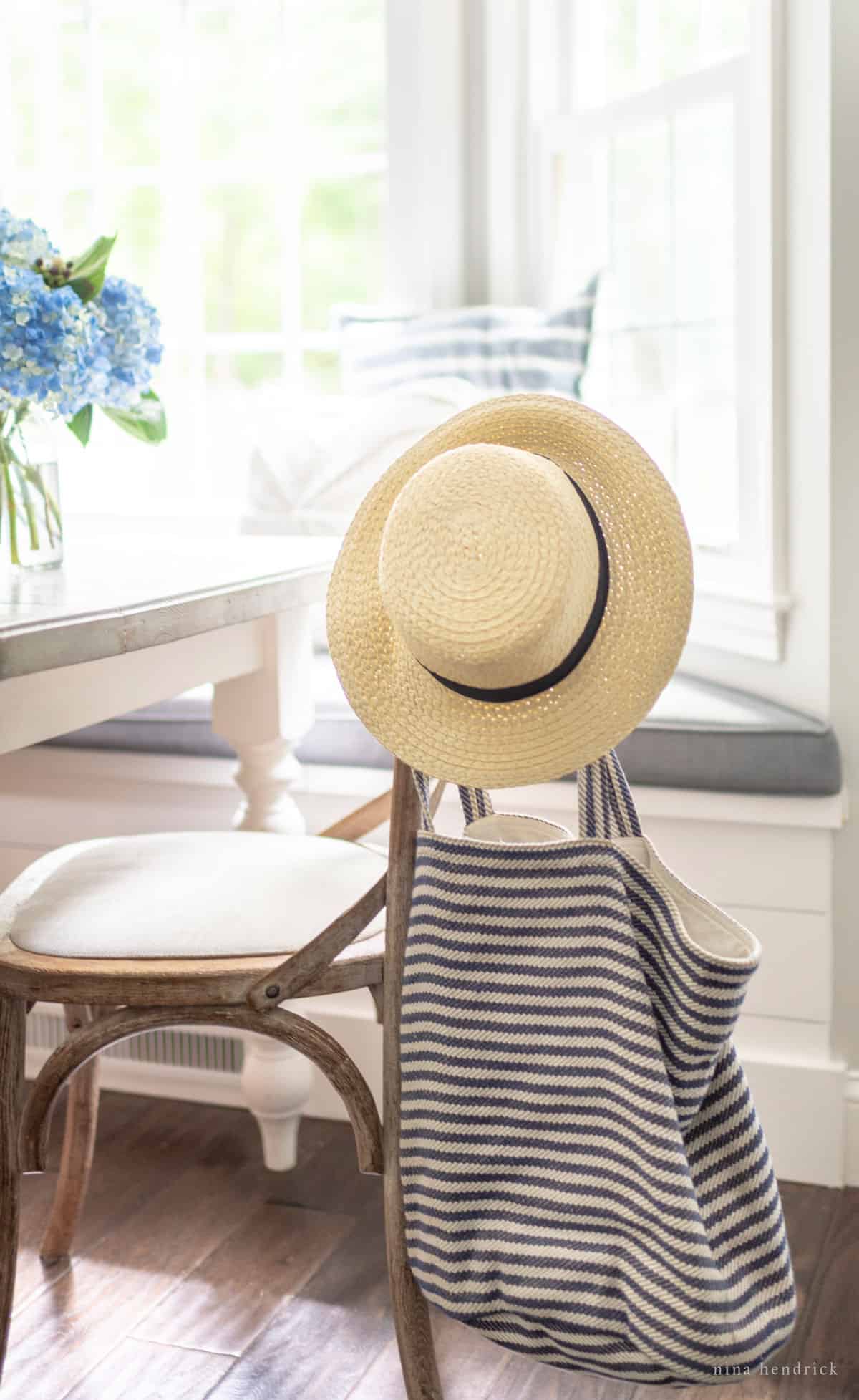 Beachy blue striped bag in a coastal dining room with a straw hat