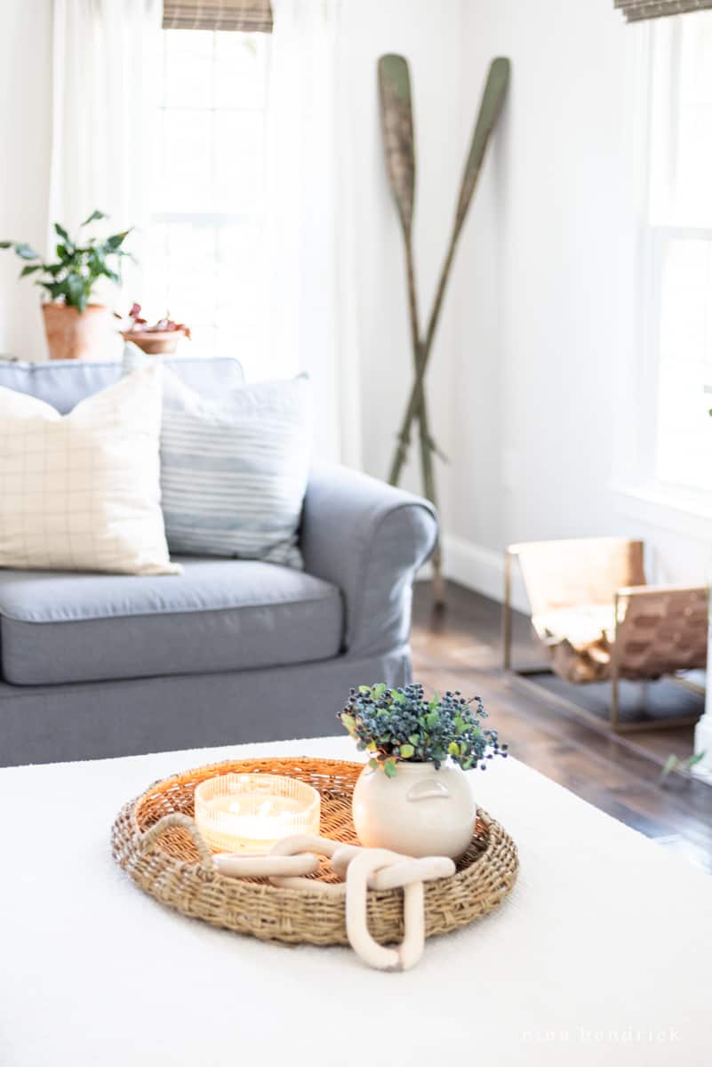 Coastal-inspired vignette with blueberries and a candle in a wicker basket in the living room
