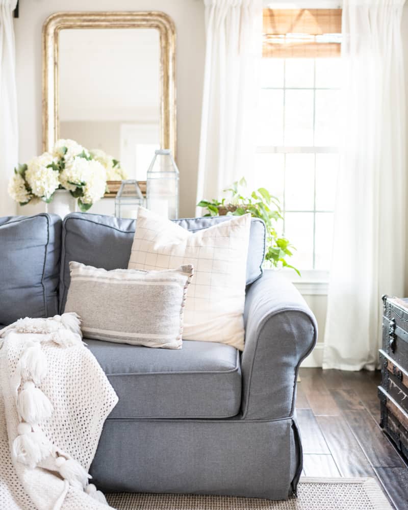 comfy sofa with neutral throw pillows and flowing curtains