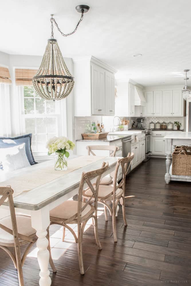 Coastal Grandmother style dining room with hydrangeas and a farmhouse table and chairs