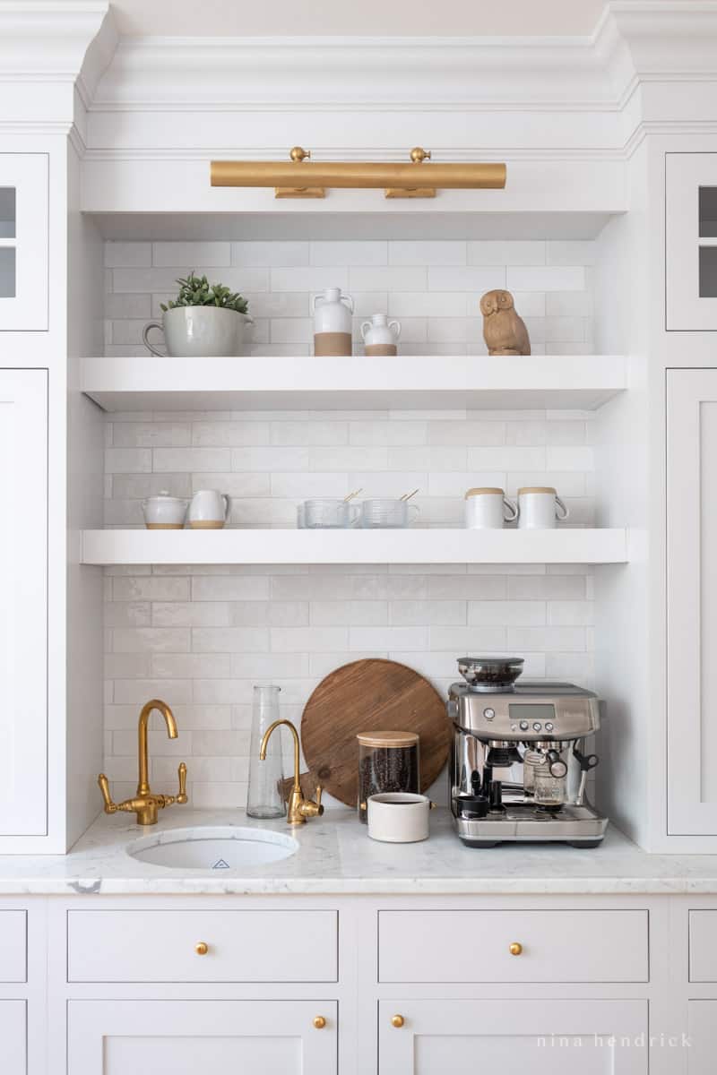 Built-in coffee bar with marble countertop. sink, hot water dispenser, and espresso machine