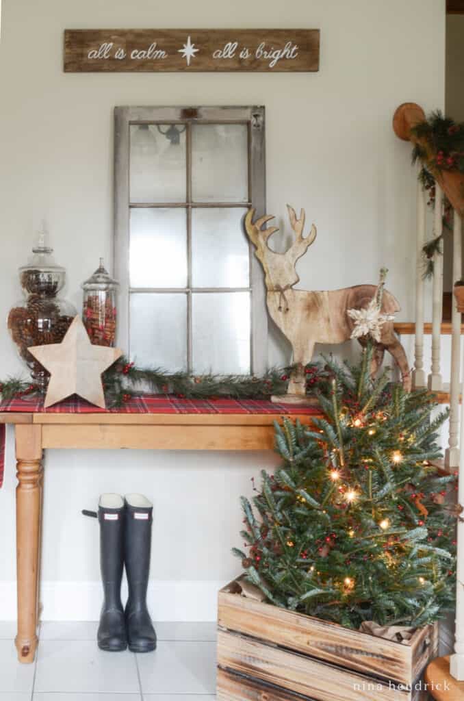 Cozy Christmas vignette with rustic decor and a miniature Christmas tree in a wooden crate.