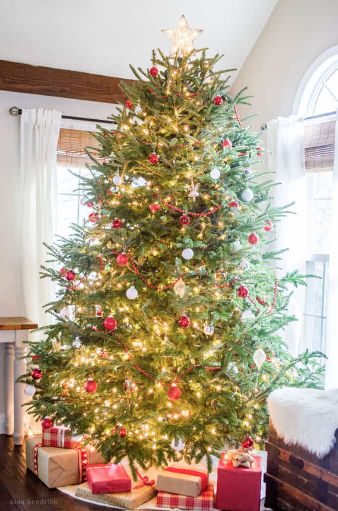 Spruce Christmas tree with Cozy Christmas decorations in red, white, and silver.