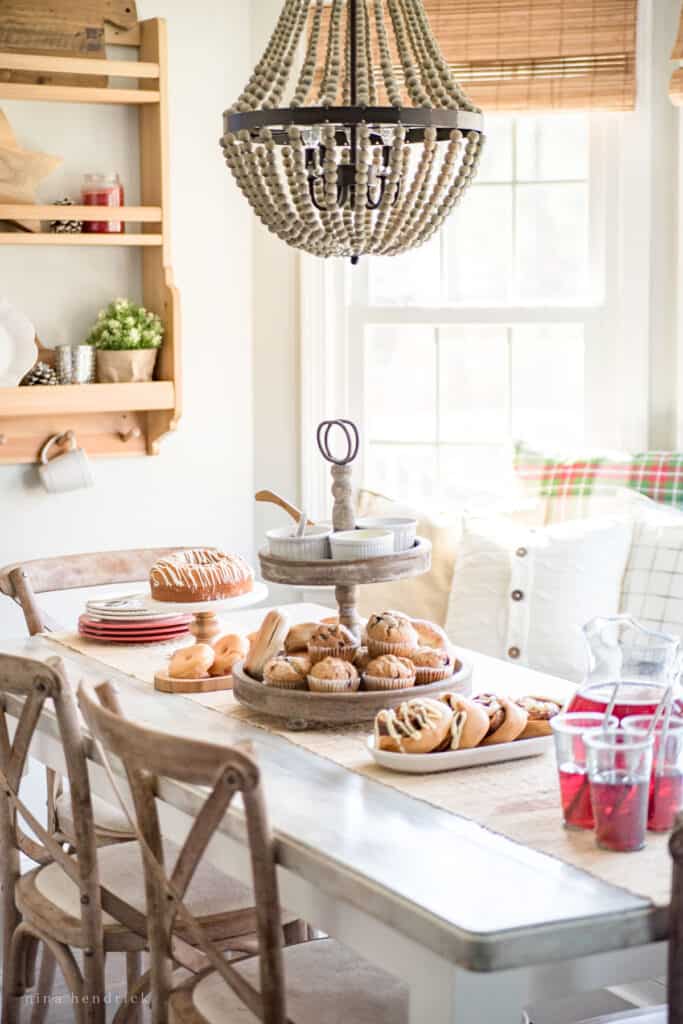 Cozy Christmas brunch with pastries, muffins, and juice set out in a white breakfast nook