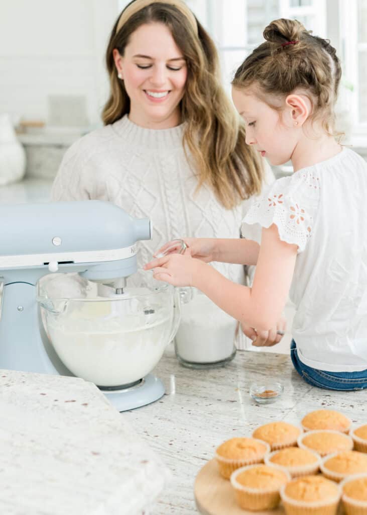 Mother and daughter baking cupcakes in the kitchen with stand mixer