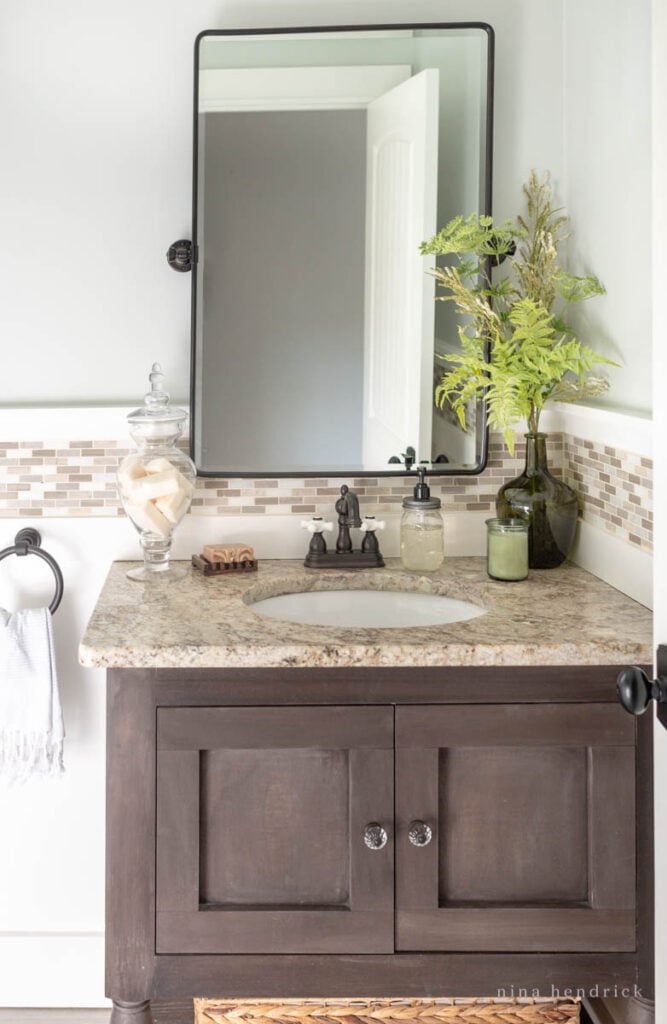 Bathroom sink with granite countertop and dark pivot mirror