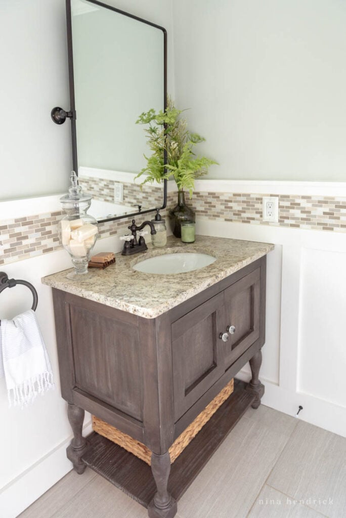 White board-and-batten bathroom with dark wood sink console