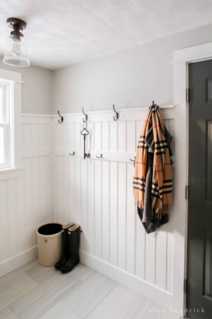 Divided beadboard wall treatment with coat hangers and boots