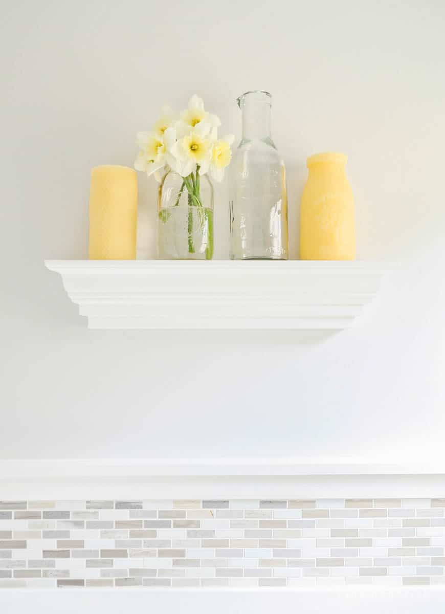 Shelf with yellow candles and daffodils