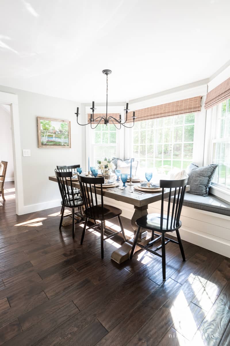 Dining area with dark hardwood floors and a built-in bay window bench.