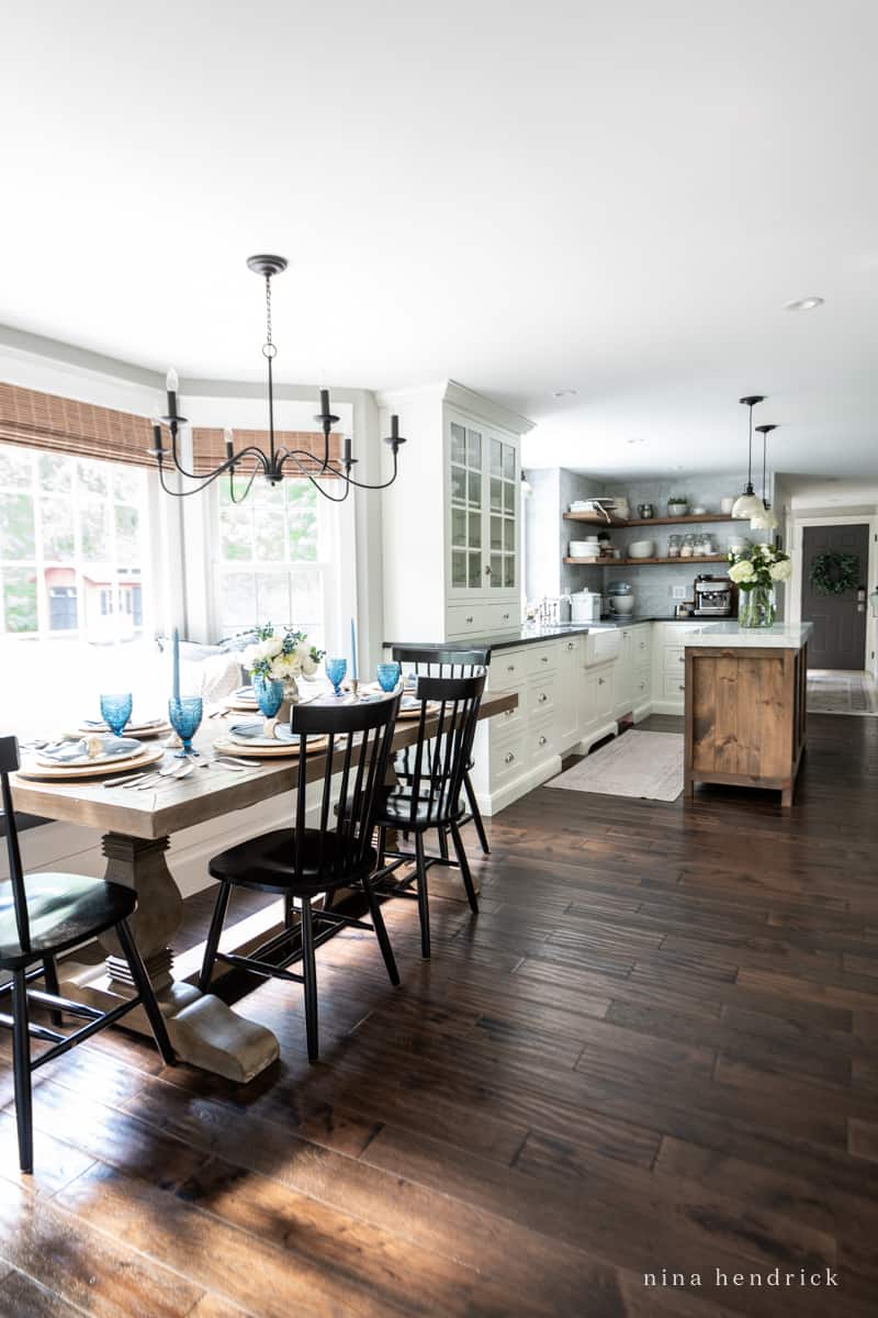 Kitchen with white cabinets and eat-in dining area with dark hardwood floors. 