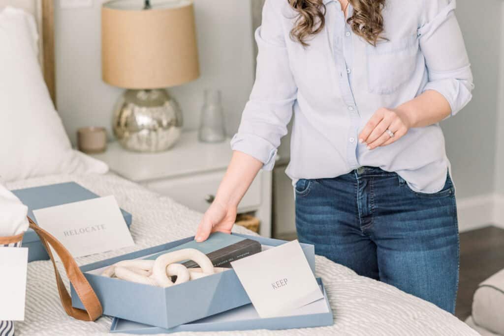 Woman organizing and sorting items into boxes for keeping and relocating 