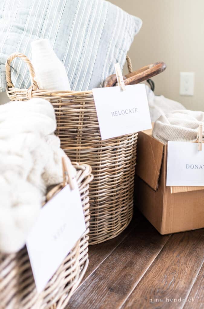 Baskets and boxes with relocate and donate signs for decluttering 