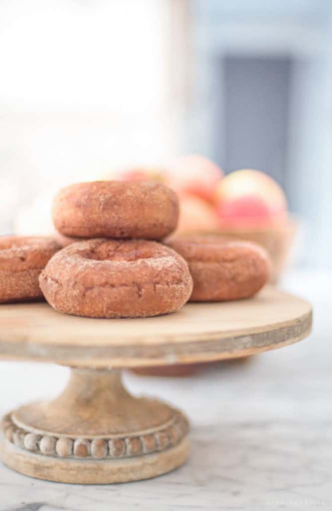 pumpkin donuts on a wooden cake stand
