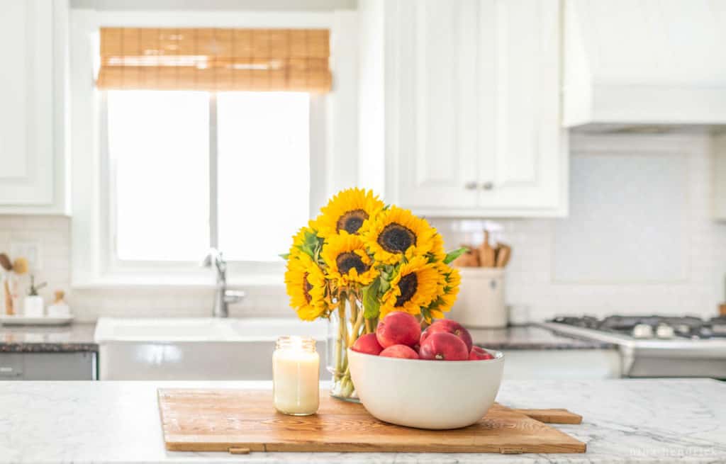 white kitchen cabinets with a candle, fruit bowl, and candle