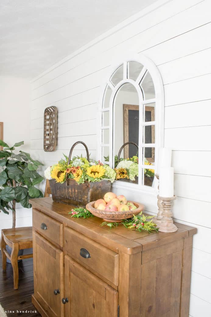 wood buffet with mirror and basket of flowers