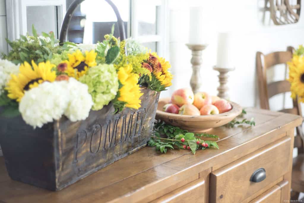wood basket of flowers and bowl of apples