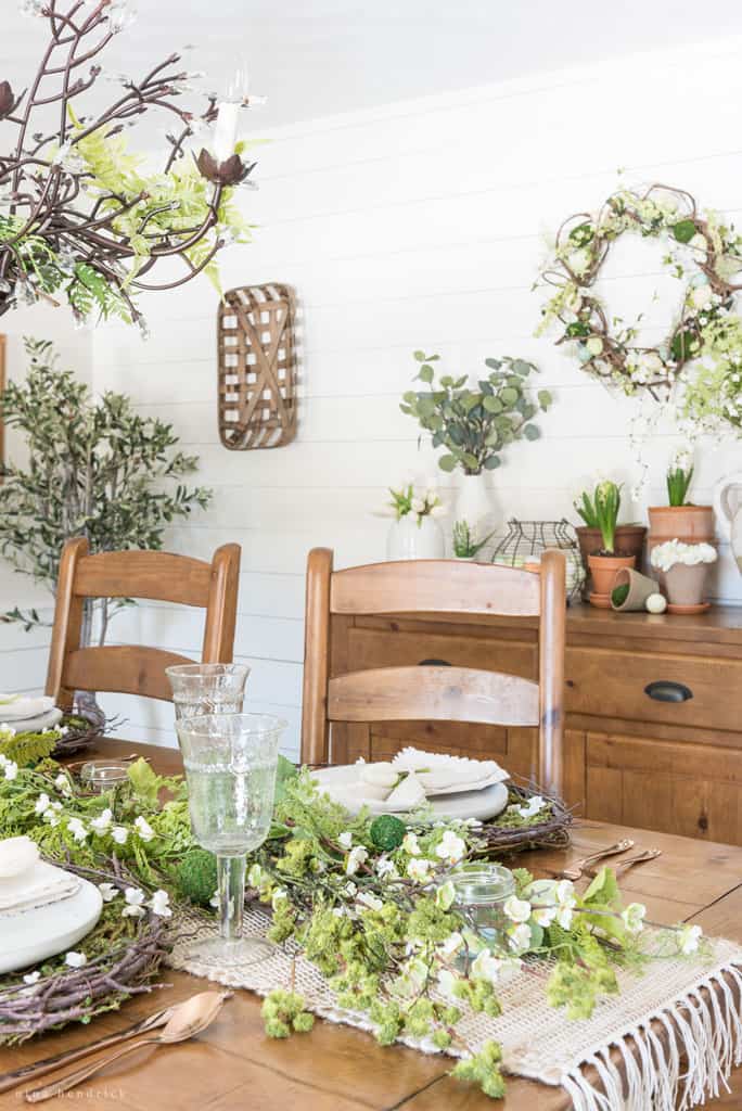 Nature-inspired spring tablescape with moss, ferns, twigs, and blossoms.