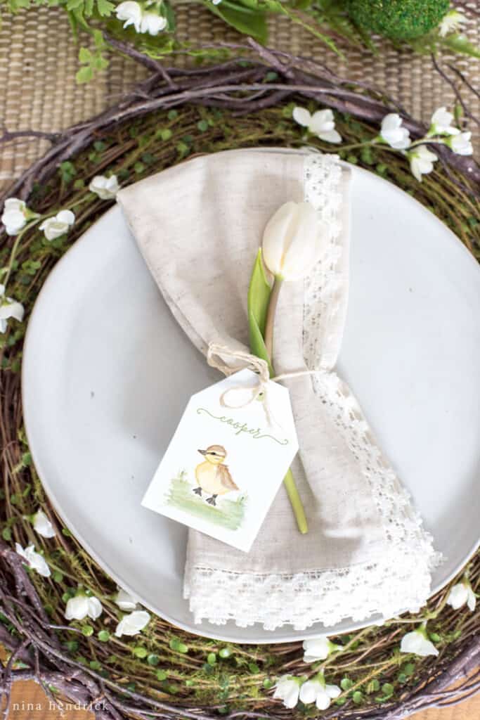 Easter place setting with twig charger, linen napkin, and printable spring baby animal place card.