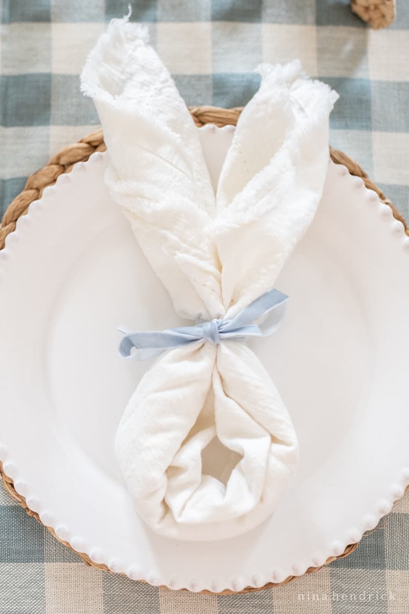 Easter bunny folded napkin on a white plate.