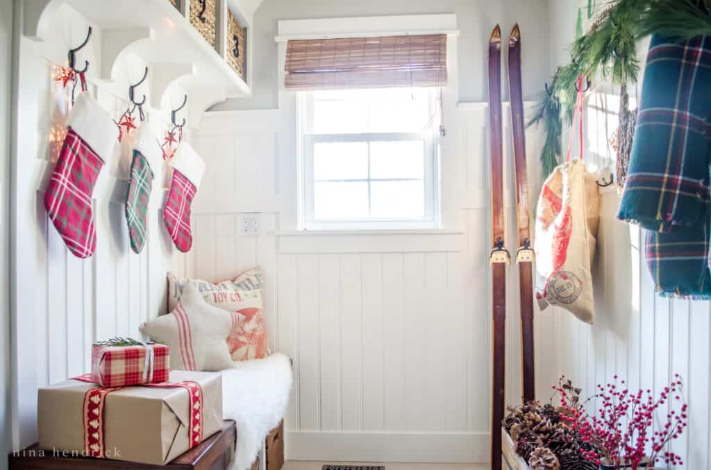 Mudroom with vintage skis, Christmas presents, and red berries