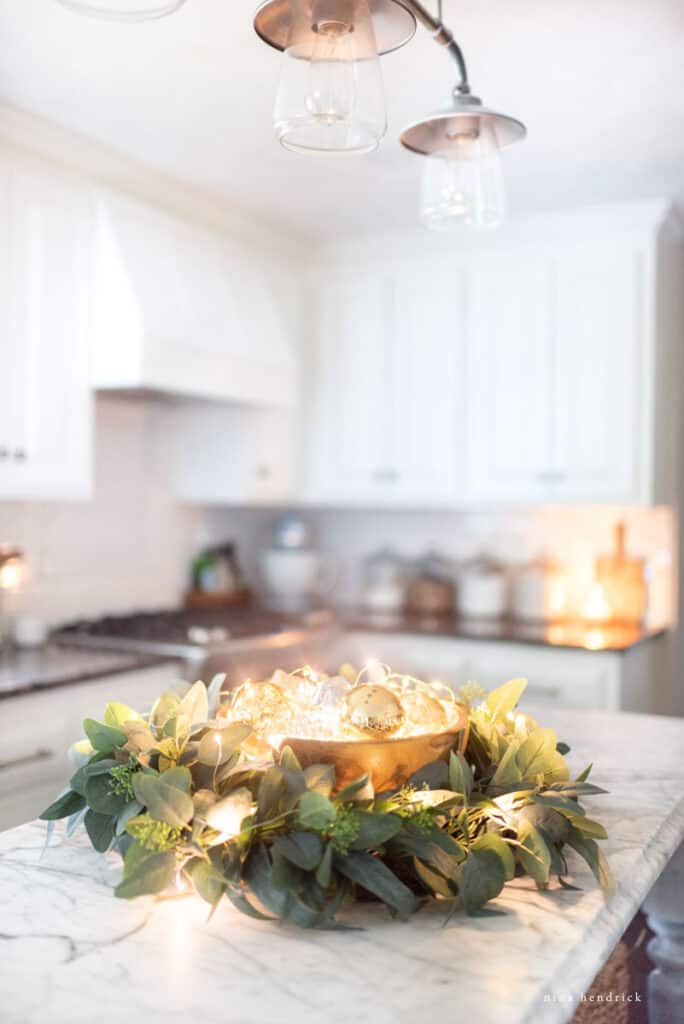 Bowl with wreath filled with ornaments and Christmas lights for a kitchen centerpiece