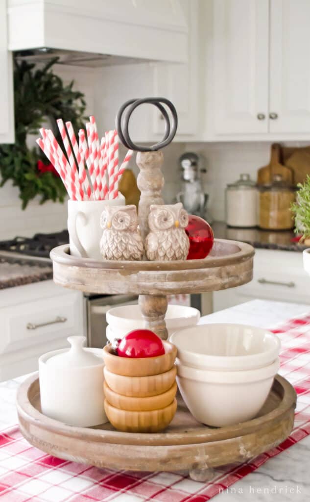 Easy Christmas Decorating Idea with a two-tiered tray, candy cane straws, and red ornaments